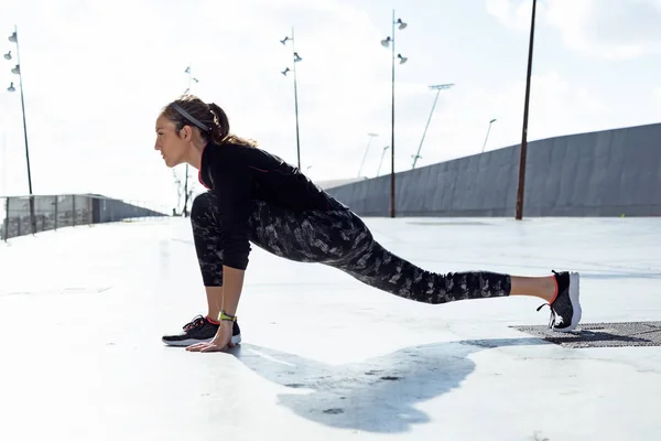 Adatto e sportivo giovane donna che fa stretching in città. — Foto Stock