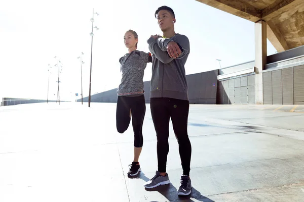 Due giovani donne in forma e sportive che fanno stretching in città . — Foto Stock