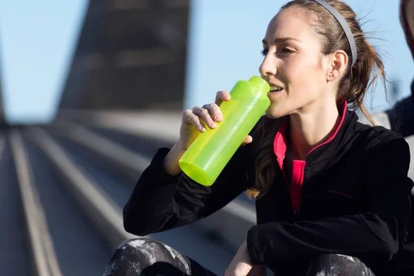 Fit en sportief jonge vrouw drinkwater. — Stockfoto