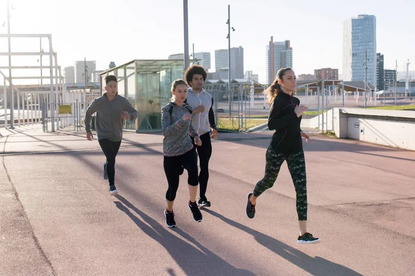 Portrait of group of friends running in the city. — Stock Photo, Image