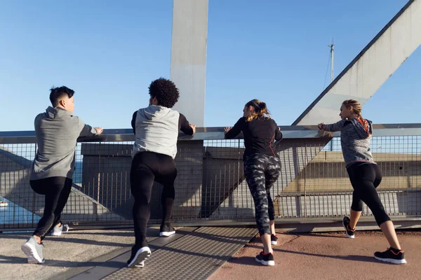 Portrait of running people doing stretching in the city. — Stock Photo, Image