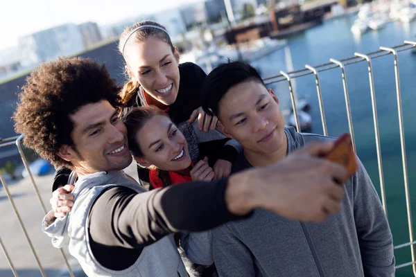 Fit e equipe esportiva usando telefone celular na cidade . — Fotografia de Stock