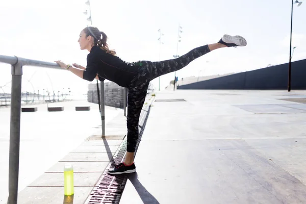 Adatto e sportivo giovane donna che fa stretching in città. — Foto Stock