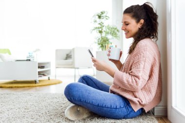 Güzel genç kadın cep telefonu evde kullanma.