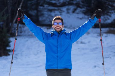 Yakışıklı genç adam kış arka plan üzerinde eğleniyor.