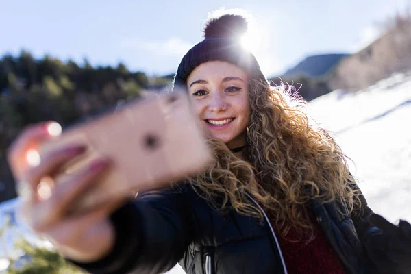 Bella giovane donna che utilizza il suo telefono cellulare sopra backgro inverno — Foto Stock
