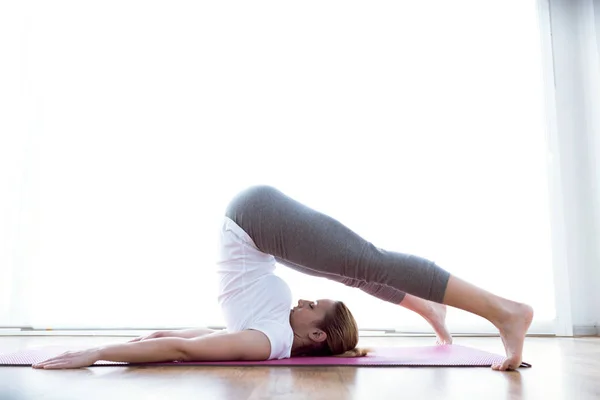 Hermosa joven saludable haciendo ejercicio en casa . — Foto de Stock