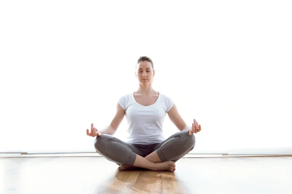 Mooie jonge vrouw doen yoga oefeningen thuis. — Stockfoto