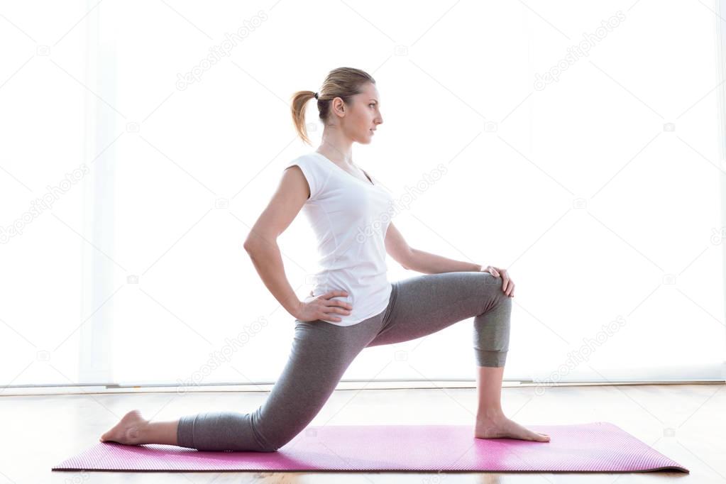 Beautiful healthy young woman doing exercise at home.