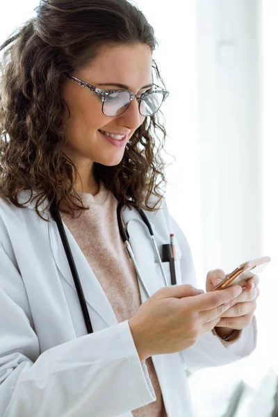 Medico femminile che utilizza il suo telefono cellulare nella consultazione . — Foto Stock