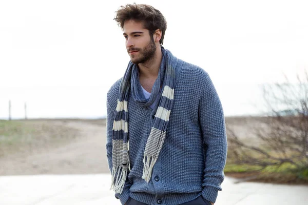 Beau jeune homme posant dans un hiver froid sur la plage . — Photo