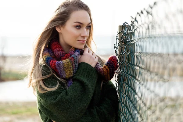 Hermosa joven posando en un frío invierno en la playa . — Foto de Stock