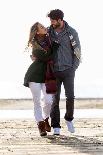 Красивая молодая пара влюблена, гуляя в холодную зиму на пляже . — стоковое фото