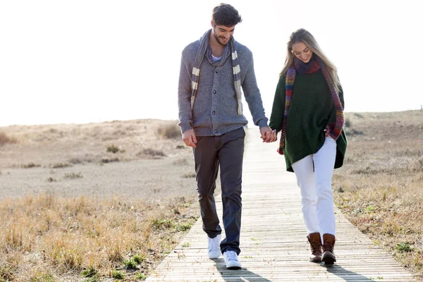 Bella giovane coppia innamorata che cammina in un inverno freddo sulla spiaggia . — Foto Stock