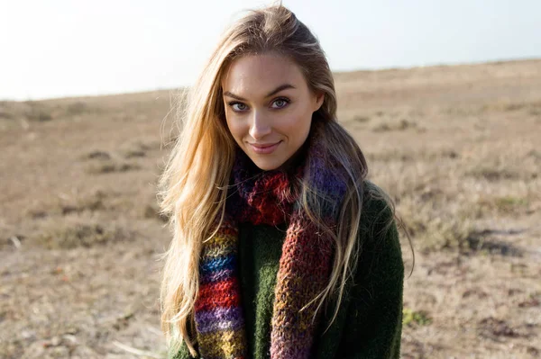 Mooie jonge vrouw poseren in een koude winter op het strand. — Stockfoto