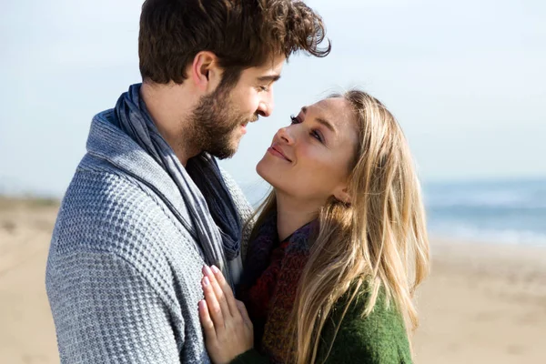 Beautiful young couple in love in a cold winter on the beach. — Stock Photo, Image