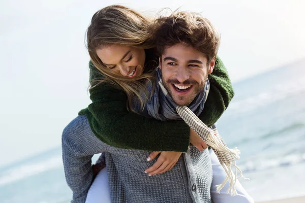 Happy young couple enjoying the day in a cold winter on the beach. — Stock Photo, Image
