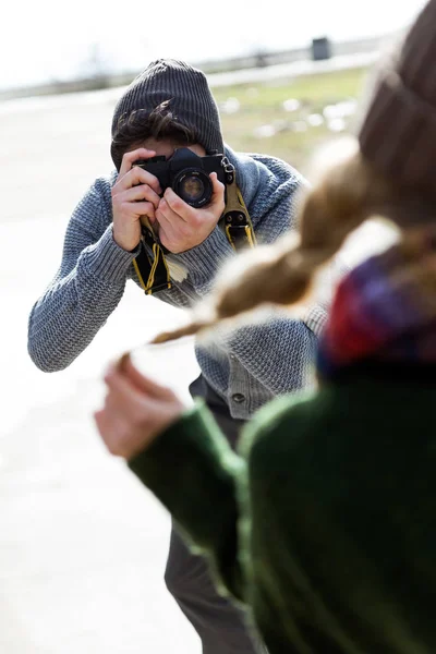 Happy young couple taking photos with camera in a cold winter on the beach. — Stock Photo, Image