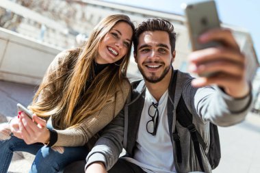 Cep telefonuyla sokakta güzel genç Çift.