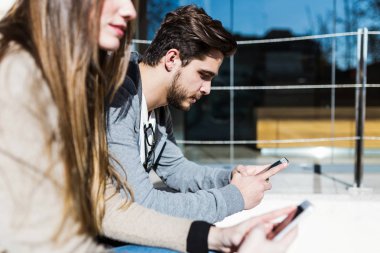 Cep telefonuyla sokakta güzel genç Çift.