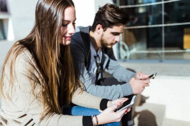 Cep telefonuyla sokakta güzel genç Çift.