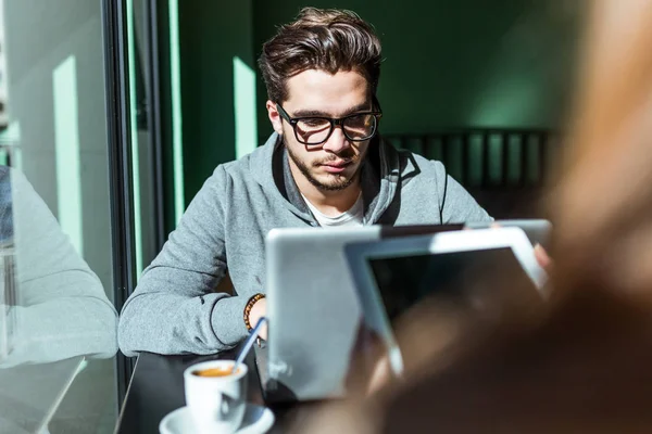 Yakışıklı genç adam onun laptop kahveye kullanarak. — Stok fotoğraf