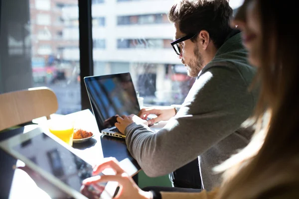 Belo jovem casal trabalhando com laptop no café . — Fotografia de Stock