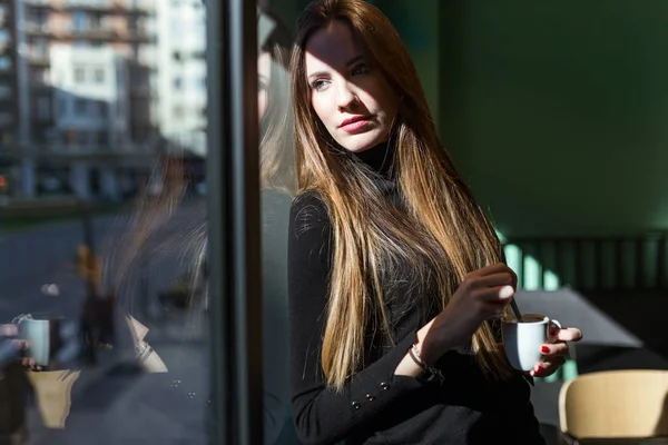 Schöne junge Frau posiert im Kaffee. — Stockfoto