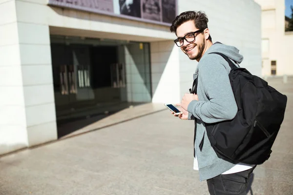 Knappe jongeman met behulp van zijn mobiele telefoon in de straat. — Stockfoto