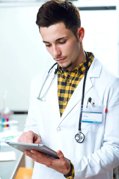 Knappe jonge man aan het werk met digitale tablet in laboratorium. — Stockfoto