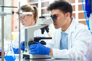 Bir laboratuvar deney yerine getiren genç bilim adamları.