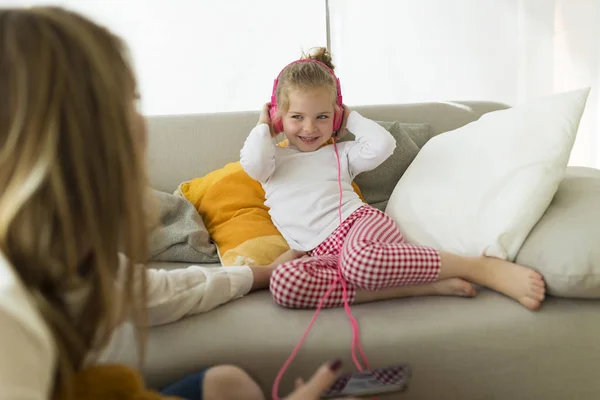 Vacker mor med dottern musik hemma. — Stockfoto