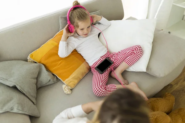 Belle mère avec sa fille écoutant de la musique à la maison . — Photo