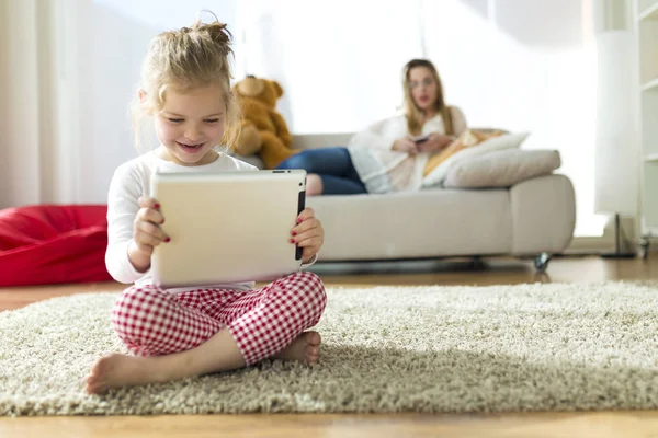 Красива дитина грає з цифровим планшетом вдома . — стокове фото