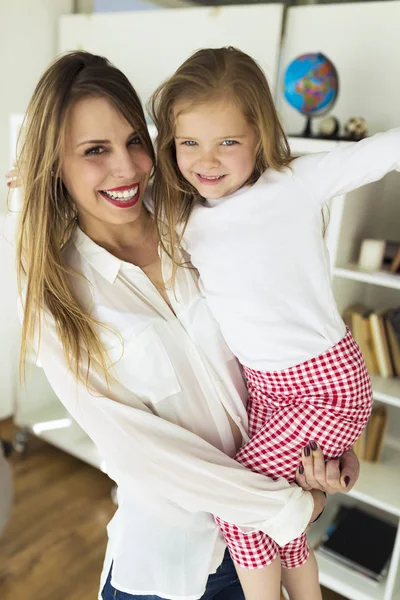 Moeder met haar dochter plezier thuis. — Stockfoto