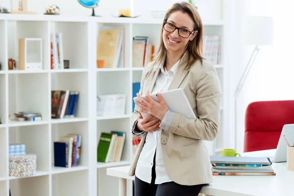 Mooie jonge vrouw kijken camera in het moderne kantoor. — Stockfoto