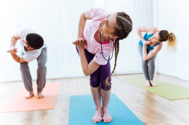 Bir grup insan evde yoga uygulamak.
