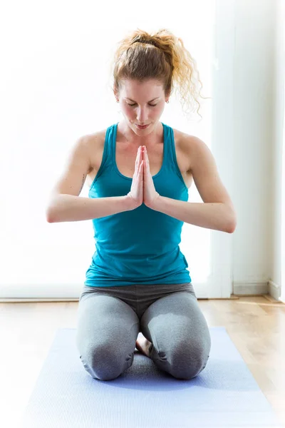 Vakker ung kvinne som øver på yoga hjemme. – stockfoto