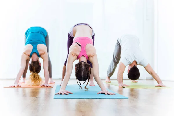 Groupe de personnes pratiquant le yoga à la maison . — Photo