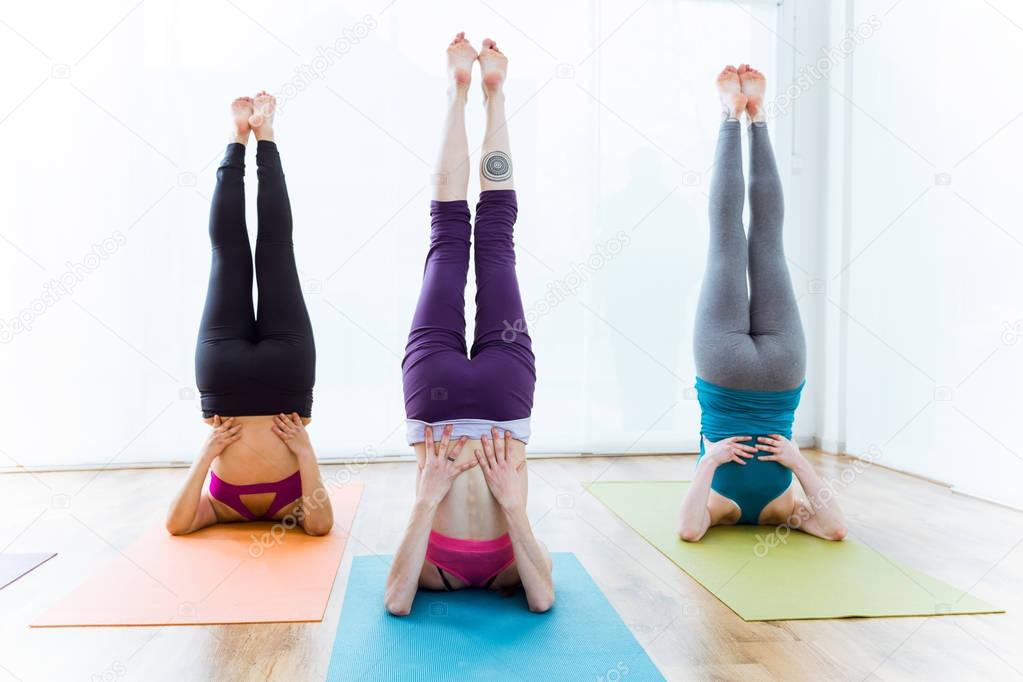 Group of people practicing yoga at home.
