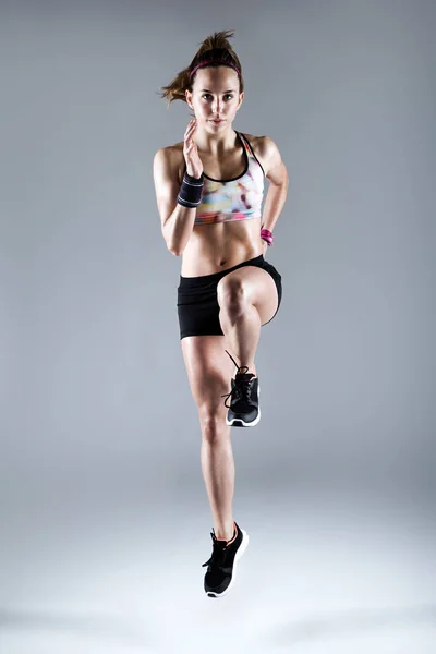 Fit en sportief jonge vrouw die worden uitgevoerd op witte achtergrond. — Stockfoto
