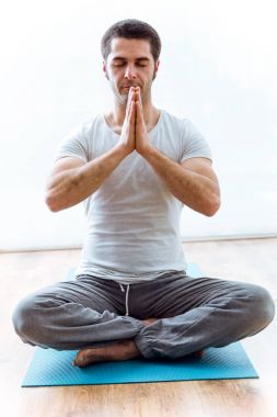 Lotus konum evde Yoga pratik güzel genç adam