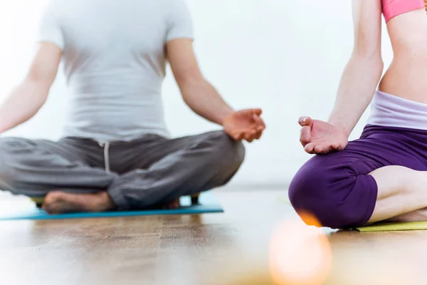 Hermosa pareja joven practicando yoga en casa en el loto posi —  Fotos de Stock