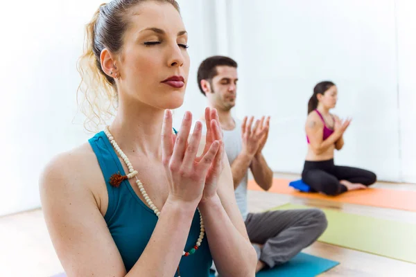 Groep van mensen die het beoefenen van yoga thuis in de lotuspositie. — Stockfoto