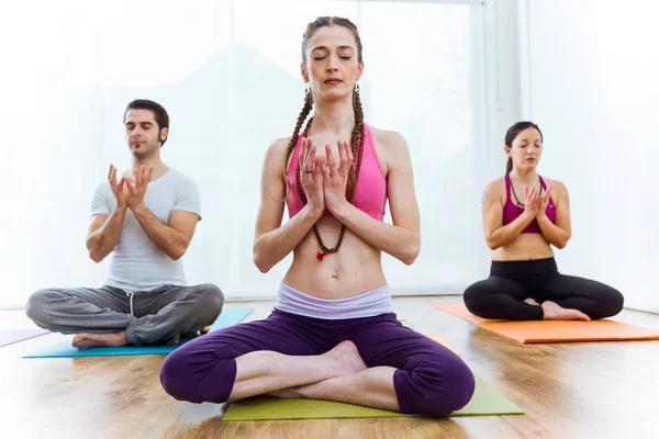 Groep van mensen die het beoefenen van yoga thuis in de lotuspositie. — Stockfoto