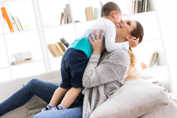 Hermosa joven madre y su hijo divirtiéndose en casa . —  Fotos de Stock