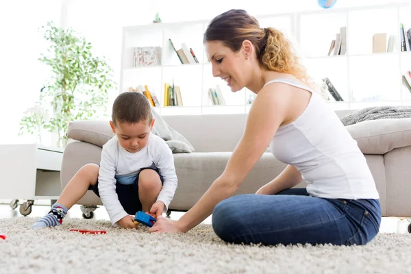 Beautiful young mother and her son having fun at home. — Stock Photo, Image