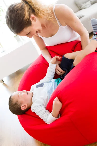 Schöne junge Mutter und ihr Sohn haben Spaß zu Hause. — Stockfoto