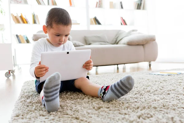 Mooie jonge jongen zijn digitale Tablet PC thuis gebruiken. — Stockfoto