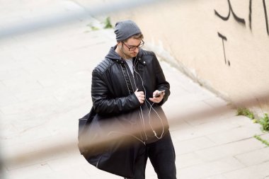 Modern genç adam sokakta cep telefonunu kullanma.